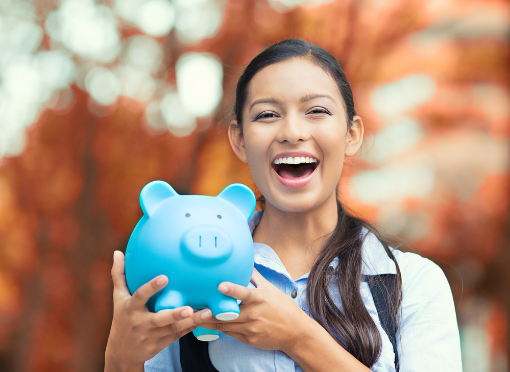 Happy woman holding piggy bank